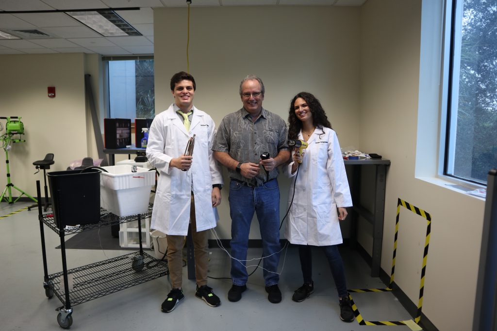 Matthew Russo (on the left)...and Clarissa Casagrande (on the right) standing next to each other holding up the cooling loop prototype. 
